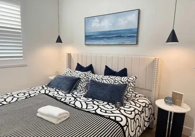 a bedroom with a large bed with blue and white pillows at #Marbella Lane - Stylish Haven Near City Center in Long Beach