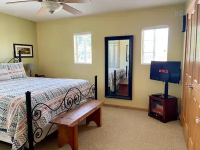 a bedroom with a bed and a tv and a mirror at Cozy Guesthouse with Private Pool and Heated Jacuzzi in Santa Clarita