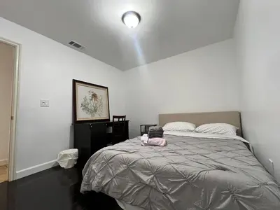 a bedroom with a bed with a pink bag on it at Near Disney,college,sunset beach ,airport in Norwalk
