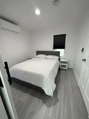 a bedroom with a white bed and a wooden floor at Gated & Morden 1bed1bath house3367 in Baldwin Park