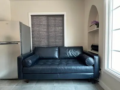 a black leather couch in a room with a window at Fully remoded 1B1B Home in baldwin Park3369A in Baldwin Park