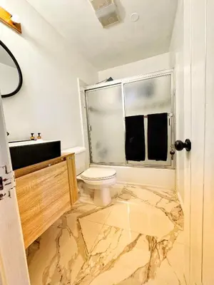 a bathroom with a marble floor and a toilet at Cozy Crestline Cabin Getaway in Crestline
