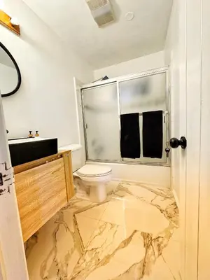a bathroom with a marble floor and a toilet at Cozy Crestline Cabin Getaway in Crestline