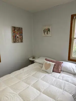 a bedroom with a large white bed with two pillows at Cozy Crestline Cabin Getaway in Crestline