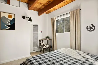 a bedroom with a bed and a desk and a window at Cowboy Cabin with Lake Views in Big Bear Lake