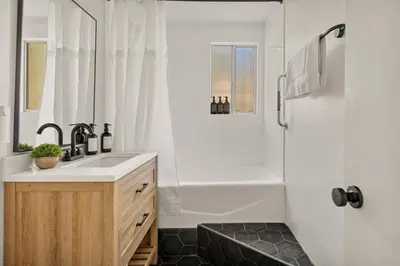 a white bathroom with a sink and a shower at Cowboy Cabin with Lake Views in Big Bear Lake