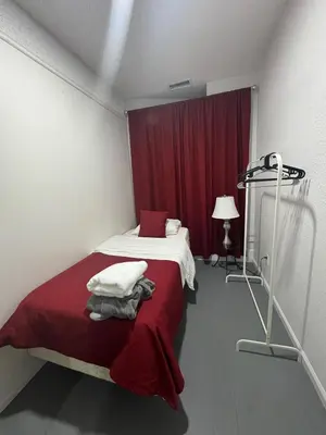 a bedroom with a bed with a red curtain at Naryn Guest house in Los Angeles
