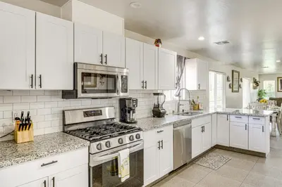 a kitchen with white cabinets and stainless steel appliances at 1 Mi to Rabobank Arena Home with Gazebo! in Bakersfield