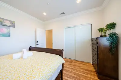 a bedroom with a bed and a dresser at 40 ppl 2 houses 13 Bedrooms btw Disney Hollywd in Monterey Park