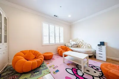 a living room with orange chairs and a couch at 40 ppl 2 houses 13 Bedrooms btw Disney Hollywd in Monterey Park