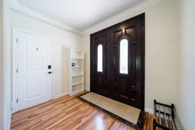 an empty room with a door and wooden floors at 40 ppl 2 houses 13 Bedrooms btw Disney Hollywd in Monterey Park