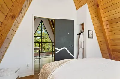 a bedroom with a bed and a large window at Midnight Chalet Big Bear Lake in Big Bear Lake
