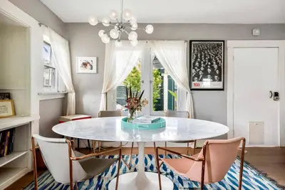 a dining room with a white table and chairs at Bougainvillea Bungalow Peaceful Venice Retreat in Los Angeles