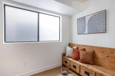 a bedroom with a wooden bench and a large window at Pacific Breeze - Modern Venice Beach Home in Los Angeles