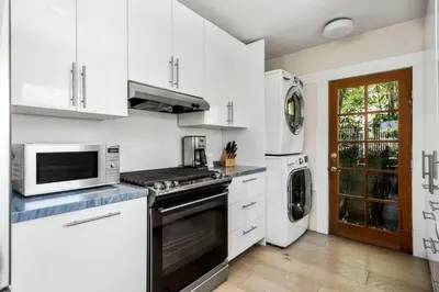 a white kitchen with a stove and a microwave at Venice Gem Private Beach Bungalow in Los Angeles