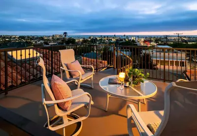 a patio with chairs and a table on a balcony at Oceanview Coastal Retreat in Redondo Beach in Redondo Beach