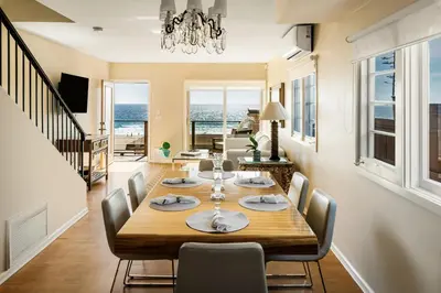 a dining room and living room with a table and chairs at New Listing The Nautilus Manhattan Beachfront Retreat in Manhattan Beach