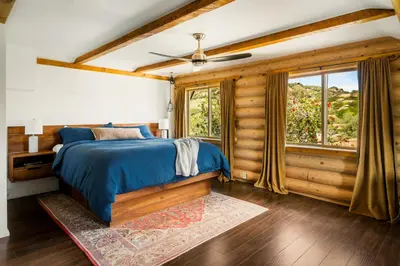 a bedroom with a blue bed and a window at Retreat to the Rocks Historic Film And Music Getaway in Chatsworth Lake Manor