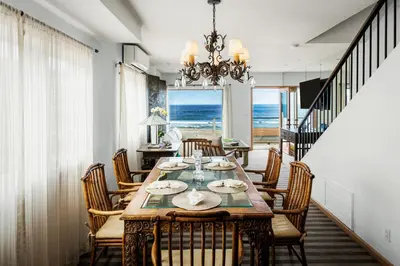 a dining room with a table and chairs and the ocean at New The Triton Manhattan Beachfront Escape in Manhattan Beach