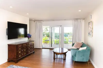 a living room with a tv and a chair and a table at Bella Villa near Beverly Hills Amazing City view and hot tub in Los Angeles