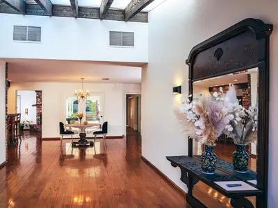 a living room with a table and a mirror at Bella Villa near Beverly Hills Amazing City view and hot tub in Los Angeles