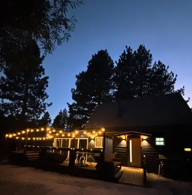 a cabin lit up at night with lights on it at The Honey Bear Cabin Jacuzzi EV Friendly Renovated in Green Valley Lake