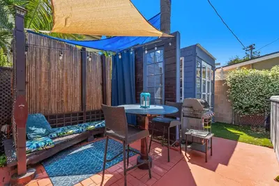 a patio with a table and chairs and a blue canopy at Spa, Parking, King Bd, Desk, 7 Min Walk to Beach in Long Beach