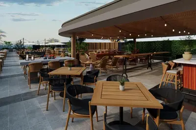 a restaurant with wooden tables and chairs on a patio at Hilton Arcadia Los Angeles in Arcadia