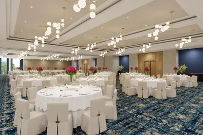 a banquet hall with white tables and white chairs at Hilton Arcadia Los Angeles in Arcadia