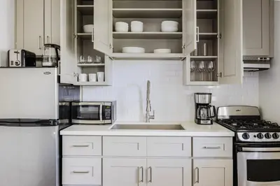 a kitchen with white cabinets and a white refrigerator at Blueground Mar Vista nr Venice Beach wd LAX-1327 in Los Angeles