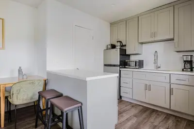 a kitchen with white cabinets and a table and chairs at Blueground Mar Vista nr Venice Beach wd LAX-1327 in Los Angeles