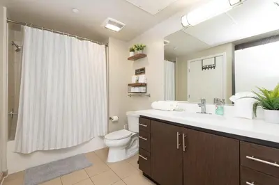 a bathroom with a sink and a toilet and a mirror at Vista Point Suites in Los Angeles