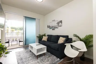 a living room with a black couch and a white table at Vista Point Suites in Los Angeles