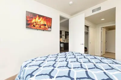 a bedroom with a bed with a fire painting on the wall at Vista Point Suites in Los Angeles