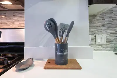a cup filled with utensils sitting on a counter at Vista Point Suites in Los Angeles
