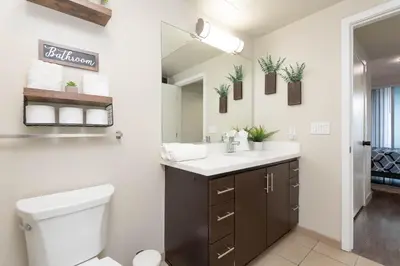 a bathroom with a sink and a toilet and a mirror at Vista Point Suites in Los Angeles