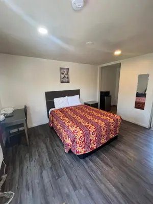a hotel room with a bed and a desk and a bed sidx sidx at World Motel in Lynwood