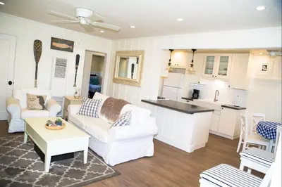 a living room with white furniture and a kitchen at 4980 Sandyland Road #216 in Carpinteria