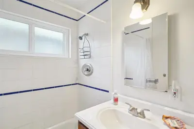 a white bathroom with a sink and a mirror at 4950 Sandyland Road #127 condo in Carpinteria