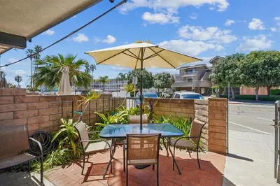 a patio with a table and an umbrella at Beach Condo with Private Patio #135 in Carpinteria