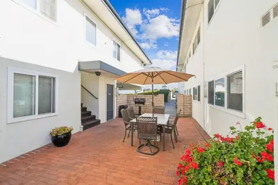 a patio with a table and chairs and an umbrella at Beach Condo with Private Patio #135 in Carpinteria