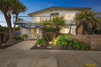 a house with palm trees in front of it at Beautiful 1 Bed Beach Balcony Condo #207 in Carpinteria
