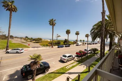 a view of a street with cars and palm trees at Beautiful 1 Bed Beach Balcony Condo #207 in Carpinteria