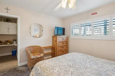 a bedroom with a bed and a dresser and a chair at Lovely 1 Bed Beach Condo #128 in Carpinteria