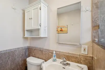 a bathroom with a toilet and a sink and a mirror at Lovely 1 Bed Beach Condo #128 in Carpinteria