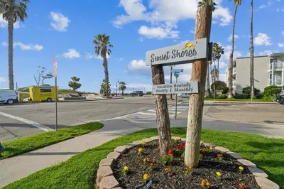 a street sign on a pole in a flower bed at Beach Condo with Private Ocean View Balcony #237 in Carpinteria