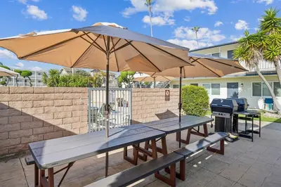 two picnic tables with an umbrella and a grill at Beach Condo with Private Ocean View Balcony #237 in Carpinteria