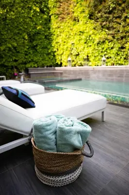 a basket of towels sitting next to a bed at NEW Modern Oasis off Melrose - Rooftop - Pool in Los Angeles