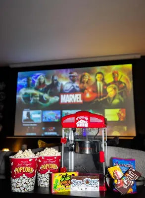a table with a popcorn maker and snacks in front of a tv at NEW Modern Oasis off Melrose - Rooftop - Pool in Los Angeles