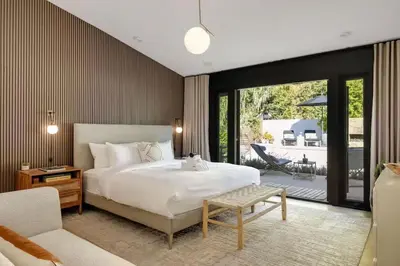 a bedroom with a large white bed and a patio at Hollywood Hills Villa by Universal - Pool - Dogs OK in Los Angeles